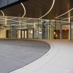 Denver Downtown Center receives a nautical themed 12 story office building with parking underground and within the first level floors using Bomanite Exposed Aggregate Sandscape Refined for the walkways and curbs under the port cochere installed by Colorado Hardscapes in Denver, CO