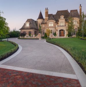 Residential Driveway receives Bomanite Exposed Aggregate Deep Washed Sandscape Texture System with a Buckskin Integral Color to Complement the Extravagant Courtyard, Basketball Brick Court and Stone Columns and Walls installed by Bomanite Toronto to withstand the Canadian Winters.
