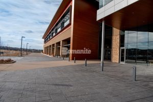 Colorado Hardscapes Installs Award Winning Bomanite Decorative Concrete Details for The Charles Schwab Conference Center at Ridgegate with a mix of Gray Bomanite Imprinted concrete systems for the field and Bomanite Exposed Aggregate Systems Sandscape Texture for accentuated bands of color.